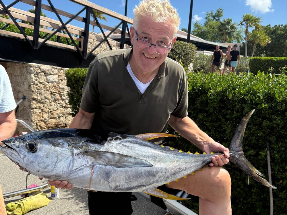 Visser met een geelvintonijn aan de waterkant, Bonaire