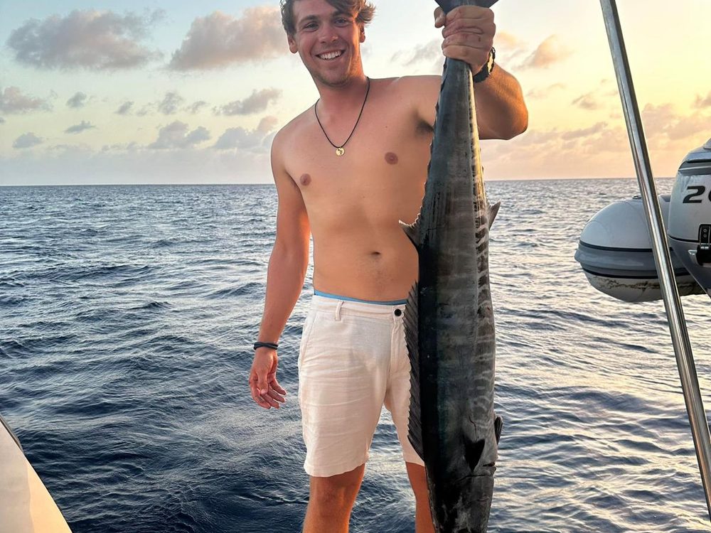 Angler with a wahoo at sunset aboard the charter off Bonaire